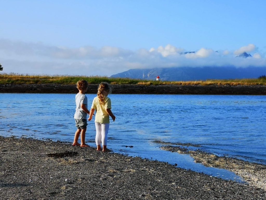 To barn står og ser utover havet.