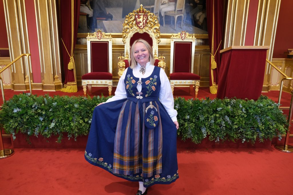 Mona Fagerås i bunad foran tronstolene i Stortinget under åpningen av Stortinget i 2021. Bilde