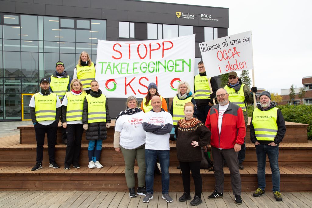 Lærere i streik ved Bodø videregående skole.De holder plakater hvor det står "Stopp tåkeleggingen KS" og "Utdanning må lønnse seg også i skolen.Bilde.