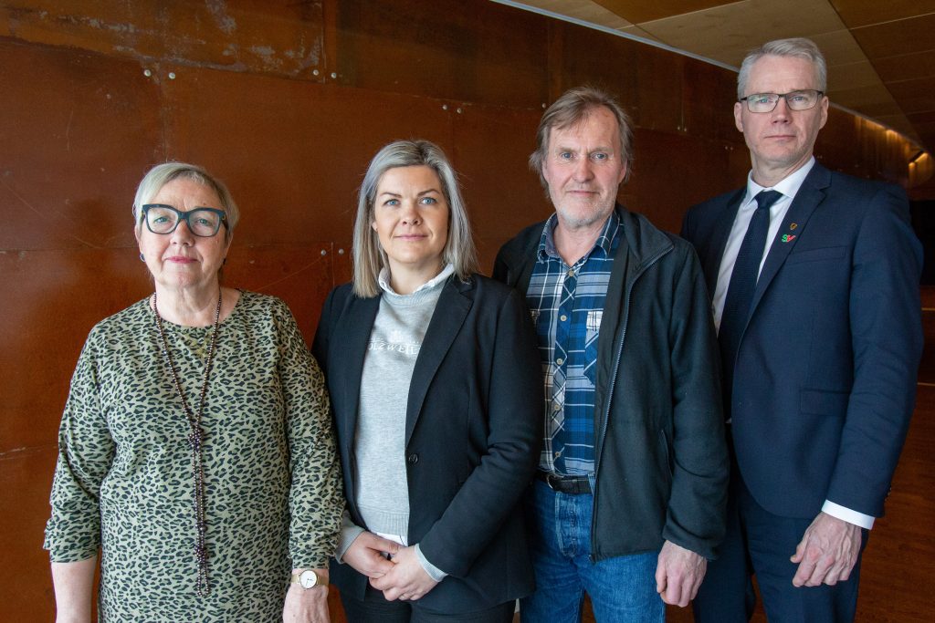 Kirsti Saxi, Aase Refsnes, Kurt Atle Hansen og Christian Torset står ved siden av hverandre inntill en nøytral vegg. Bilde.