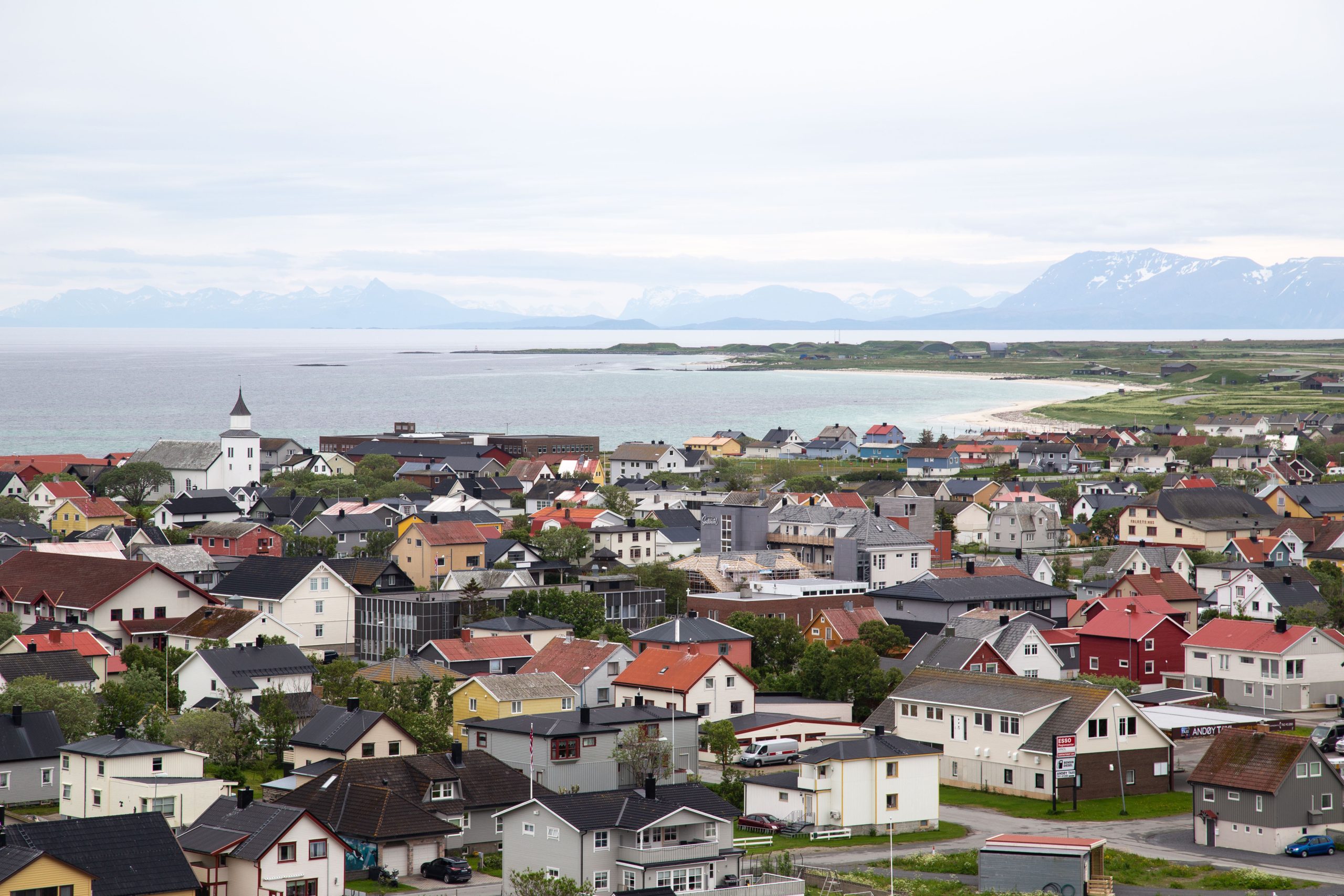 Utsikt over Andenes tatt fra Andenes fyr. Hus i forgrunnen og fjell i bakgrunnen. Bilde.