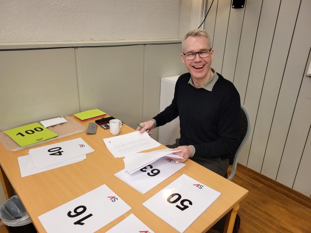 Christian Torset sitter ved bordet med delegatnummer til årsmøtet.