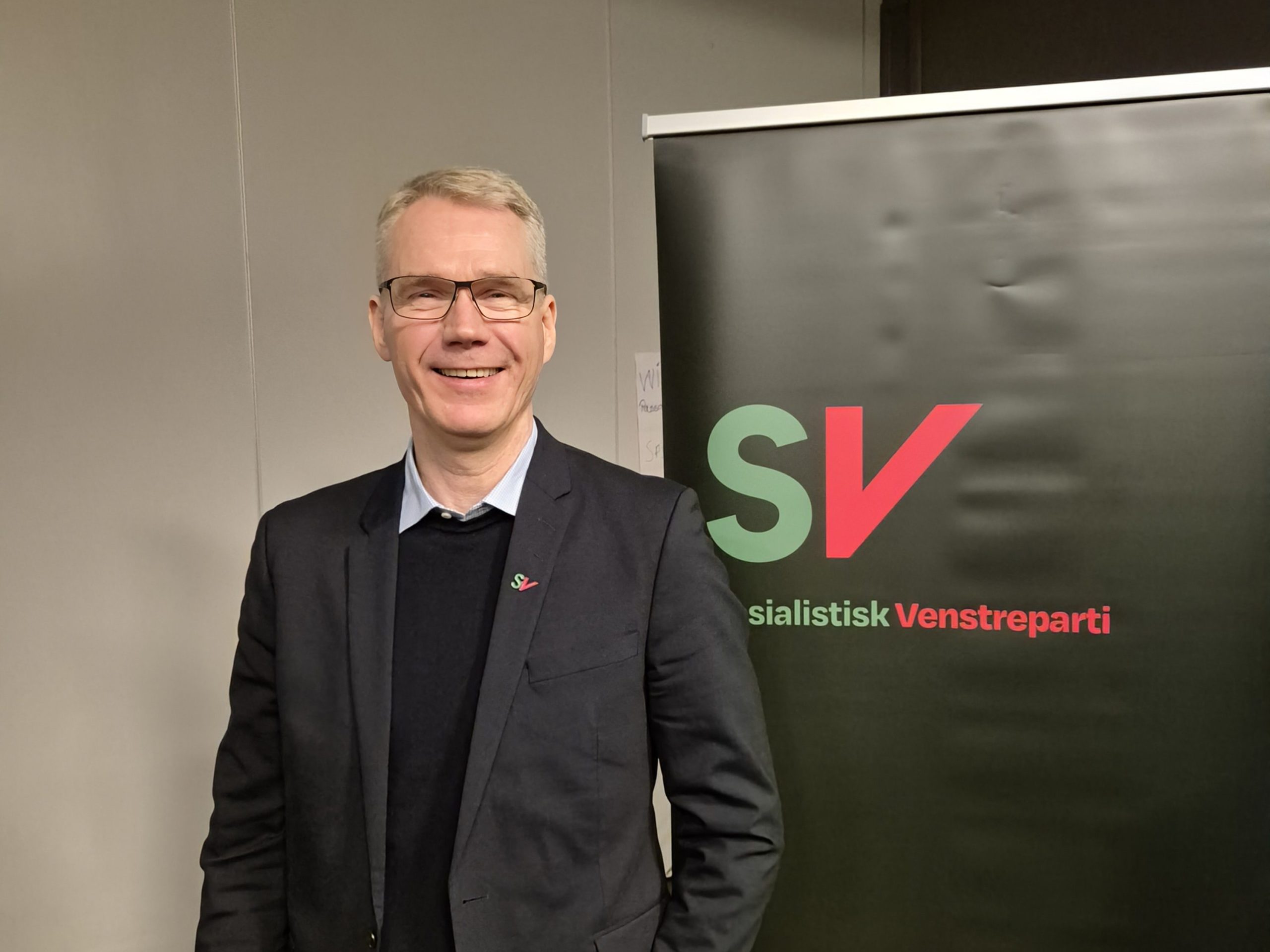 Christian Torset foran skilt med SV sosialistisk venstreparti på.